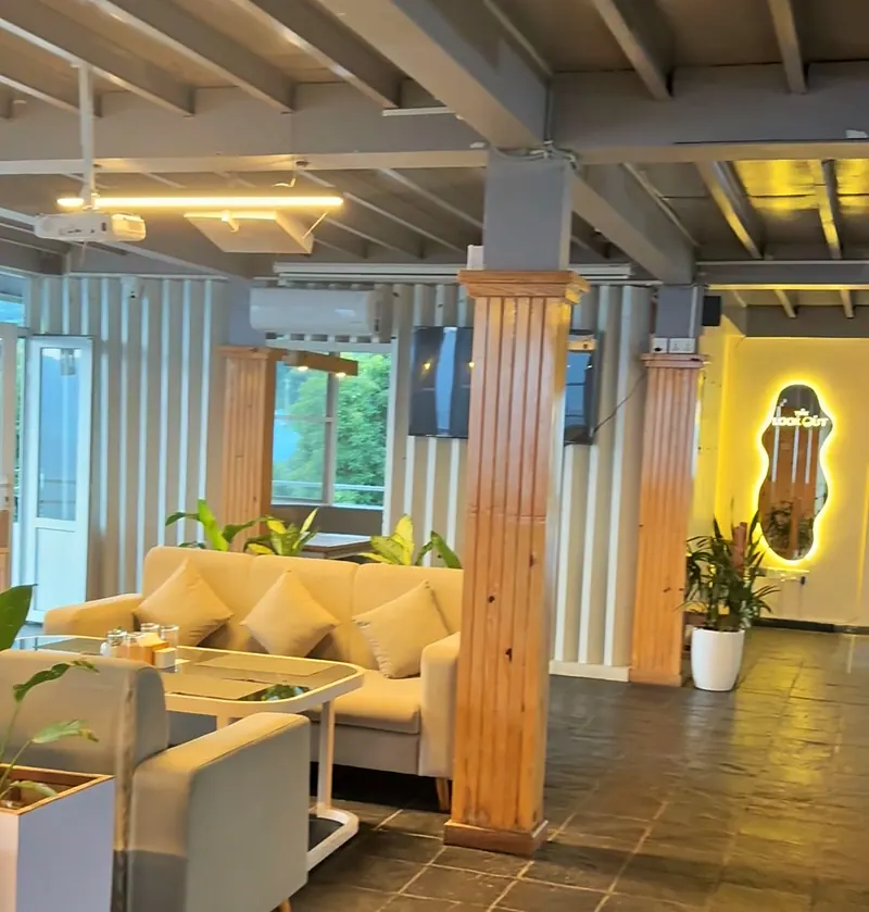 The lounge at The Lookout with cream sofas, plants, warm lights and the glowing logo mirror