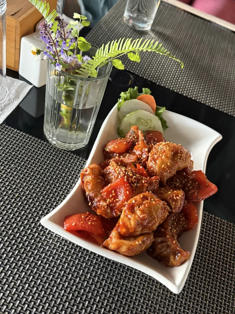 Chicken momo chilli with sesame, tomato and cucumber
